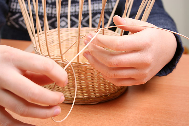 Kind flicht einen Korb